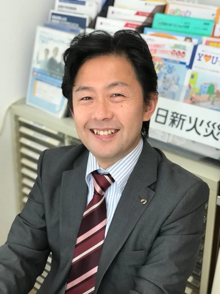 お客さまからの無料相談やお問い合わせを歓迎する、笑顔のあおば総合保険代表・高倉秀和。